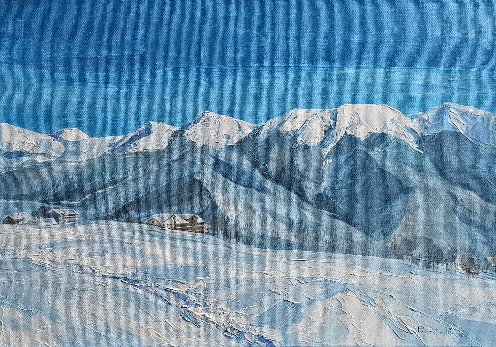 Winter landscape of snow-covered mountain ridges under a blue sky