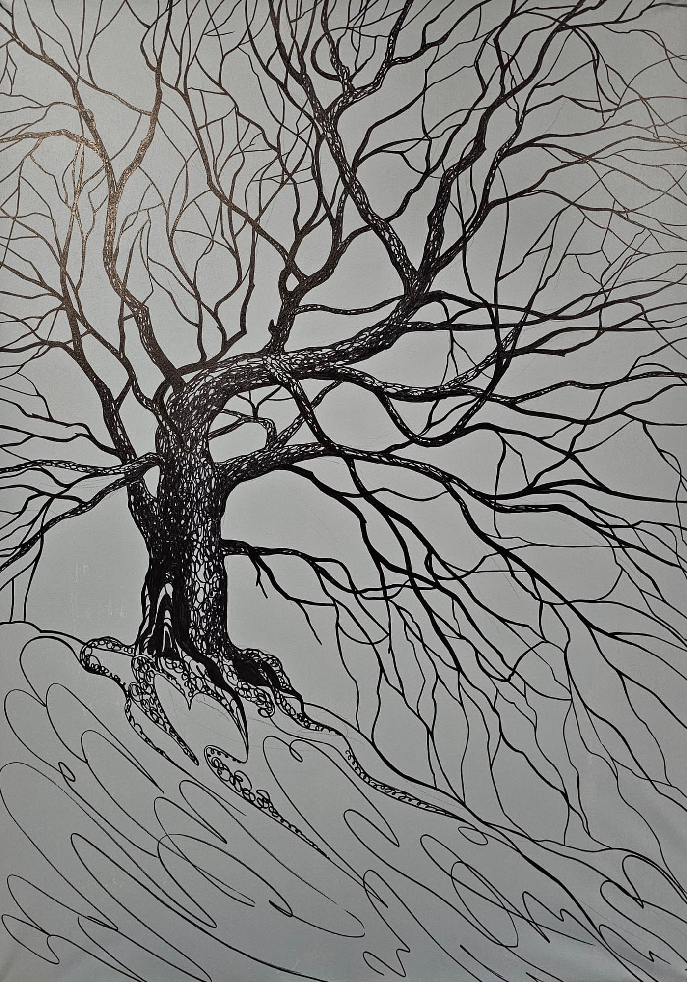 Black and white image of a bare tree with intertwined branches and roots