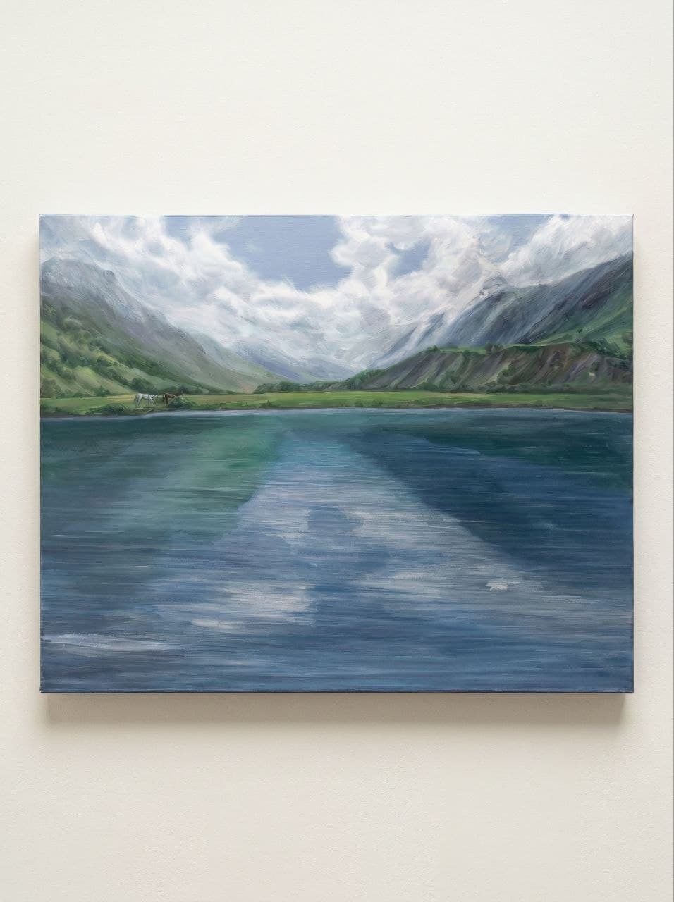 Painting of a mountain lake displayed on an interior wall